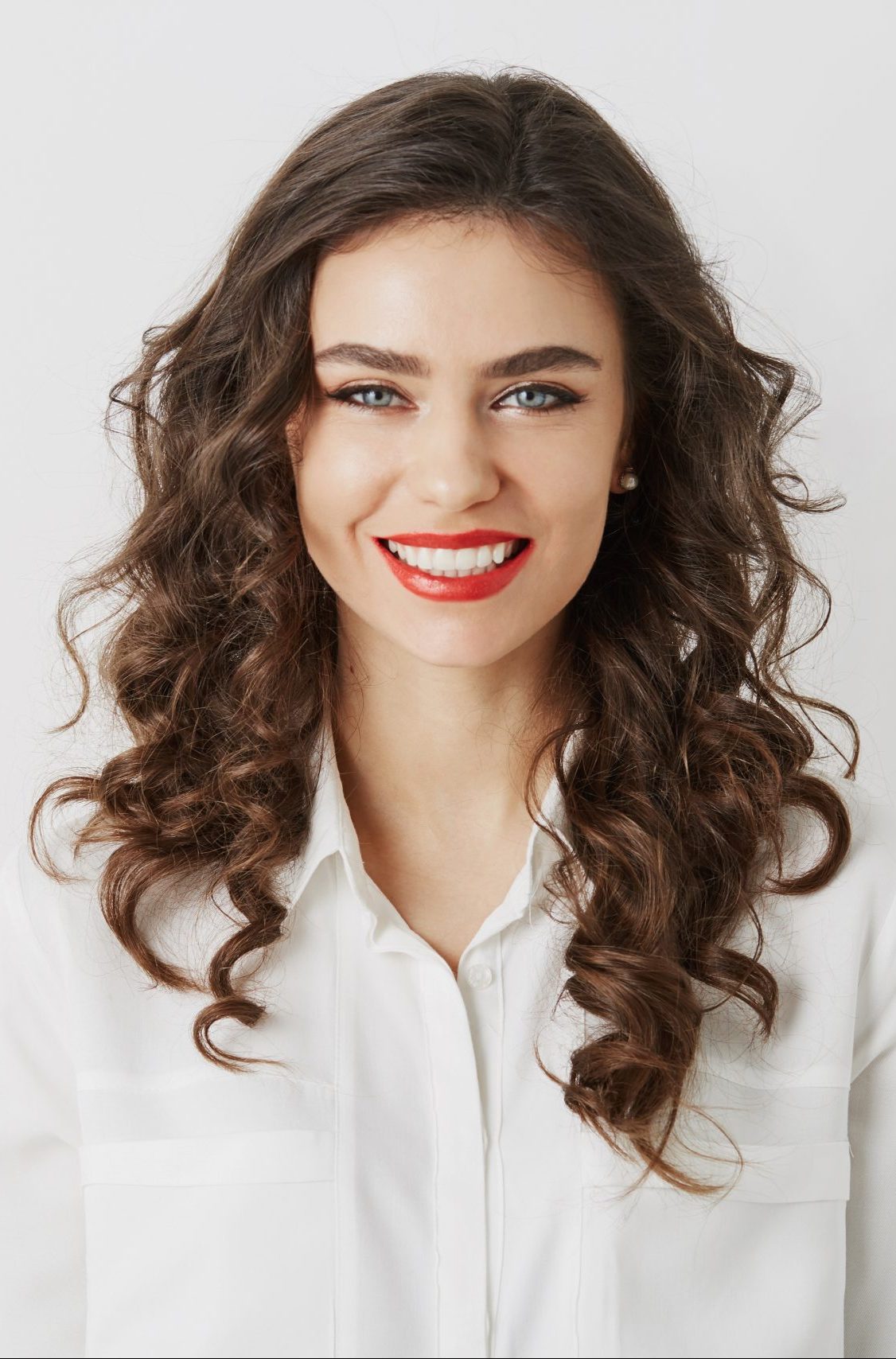 close up portrait smiling attractive woman with white teeth long curly hair red lipstick make up looking camera isolated wearing white blouse scaled e1660329497356